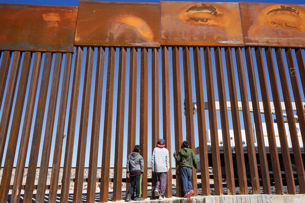 Bir çocuk Meksika 'yı Birleşik Devletler' den ayıran duvarın parmaklıklarından bakar.