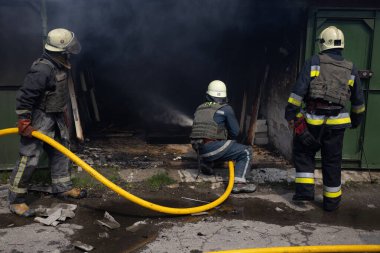 04-19-2022 itfaiyecileri, Harkiv şehrinin dışındaki Rus bombardıman uçaklarının saldırdığı bir depoda çalışıyor..