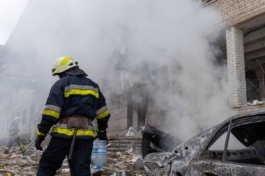 04-13-2022 itfaiyeciler ve kurtarma ekipleri Kharkiv şehrindeki bir Rus füzesi tarafından imha edilen bir binada çalışıyor.