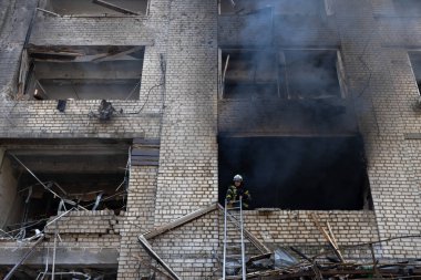 04-13-2022 itfaiyeciler ve kurtarma ekipleri Kharkiv şehrindeki bir Rus füzesi tarafından imha edilen bir binada çalışıyor.