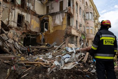 04-13-2022 itfaiyeciler ve kurtarma ekipleri Kharkiv şehrindeki bir Rus füzesi tarafından imha edilen bir binada çalışıyor.