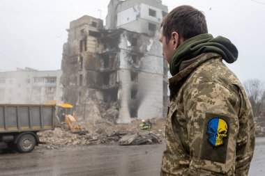 İtfaiyeciler ve kurtarma ekipleri bir Rus füzesi tarafından yıkılan bir binanın enkazını temizliyor.