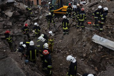 İtfaiyeciler Borodyanka 'da bir füze saldırısında hayatını kaybeden insanların cesetlerini kurtarmak için yıkılan bir binanın kalıntılarında çalışıyorlar.