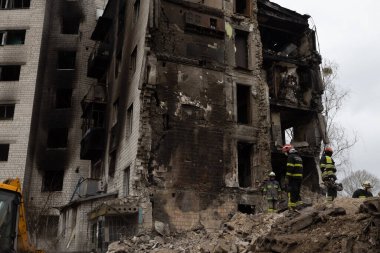 İtfaiyeciler Borodyanka 'da bir füze saldırısında hayatını kaybeden insanların cesetlerini kurtarmak için yıkılan bir binanın kalıntılarında çalışıyorlar.