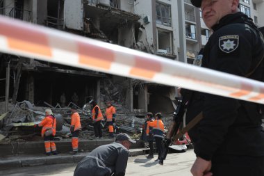 Bir polis memuru, Kyiv 'de bir Rus füzesinin bir binayı yok ettiği ve bir kadını öldürdüğü bölgeyi koruyor.