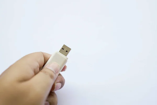 human hand on used flash drive is white, Compact USB drive, Close-up of flash memory template isolated on white.