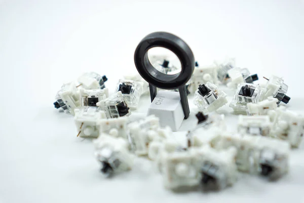 conceptual keycap puller with mechanical keyboard keycaps and black mechanical switch keys isolated on white background