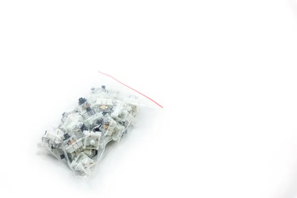 用塑料包裹在白色背景上的一套黑色机械式键盘开关键 — 图库照片