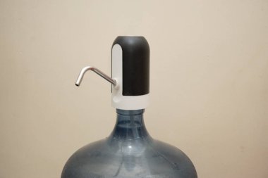 Geniş şeffaf plastiği, içme suyu ile 19 litre kapasiteyi ve şarjlı bir pil kullanarak elektrik pompasını kapatın. Beyaz arkaplanda izolasyon.