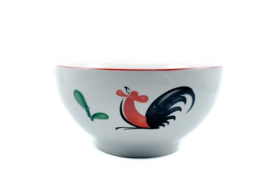 Beyaz seramik kâse üzerinde izole edilmiş tavuk resmi var.