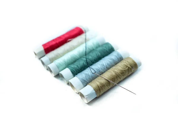 白い背景に隔離された様々な色や縫製針の縫製糸の行 — ストック写真