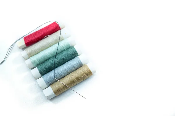 白い背景に隔離された様々な色や縫製針の縫製糸の行 — ストック写真