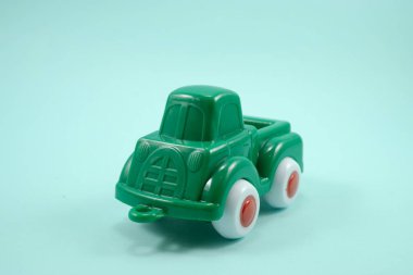 Turkuaz arka planda izole edilmiş yeşil boya plastik oyuncak kamyonu.