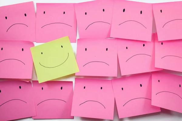 conceptual image for a happy person among an unhappy community, concept of using sticky notes.
