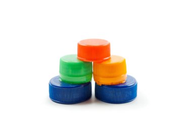 Beyaz arka planda izole edilmiş geri dönüşümlü malzemeler içeren renkli plastik şişe kapakları.