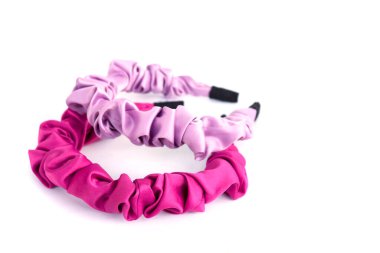 Beyaz arka planda izole edilmiş yumuşak kumaşla kaplı plastikten yapılmış güzel kırmızı ve pembe saç bandı..