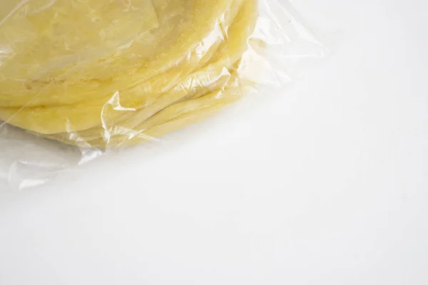 Markette satılmak üzere plastik içinde paketlenmiş ev yapımı dondurulmuş ekmek beyaz arka planda izole edilmiş..