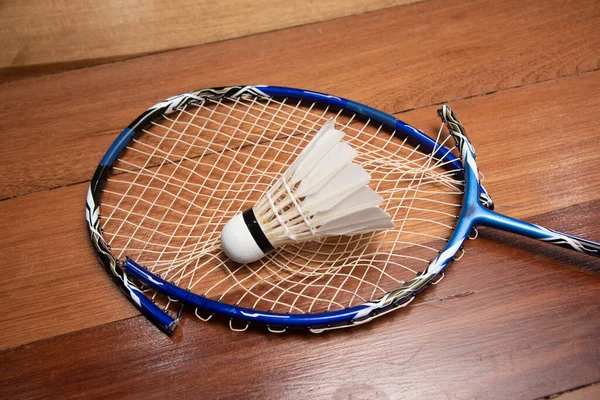 damage badminton racket with shuttle cock lay on wood table