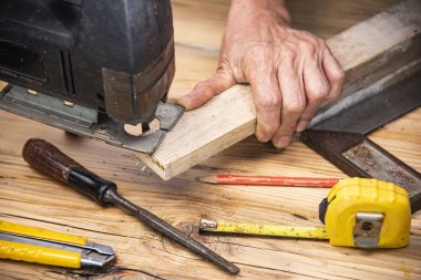 carpenter using jigsaw cut wood