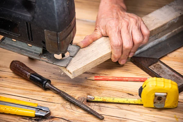 carpenter using jigsaw cut wood