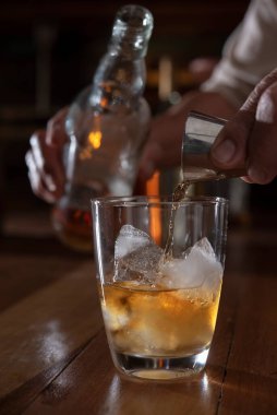 Adam eli jiggerdan cama viski dolduruyor.
