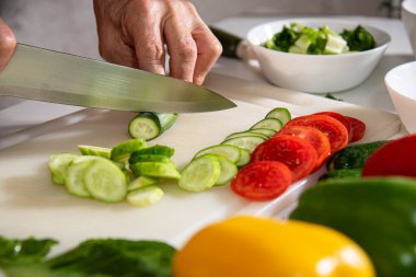 Adam eli bıçak kullanarak sebze kesiyor.