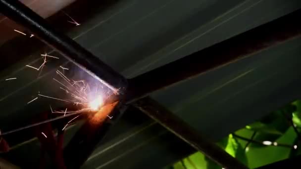 技術者は屋根の下で溶接作業を行い — ストック動画