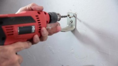 Teknisyen yangın söndürme tüpünü asmak için kancayı tamir etti