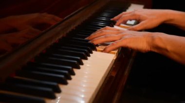 selective focus closeup pianist hand at piano key.