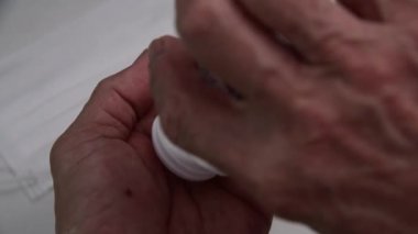 drug pouring into old man hand