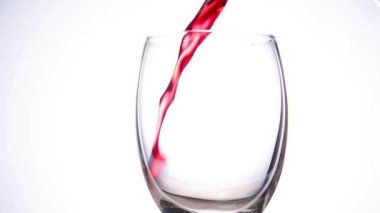 Kırmızı şarabı, izole edilmiş beyaz arka plana döküyorum.