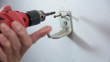  Erkek elleri elektrikli tornavida kullanıyor demir kancayı tamir ediyor.