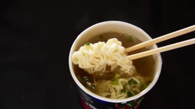 Elle yemek çubuğu yorucu erişteyi fincanda kullanın.