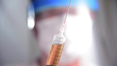 doctor clearing air in syringe for injection