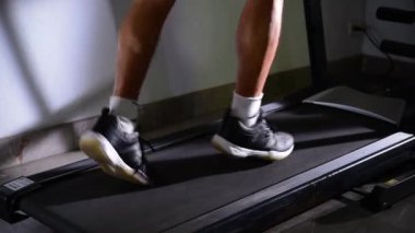 Asyalı yaşlı adamın koşu bandında koşarkenki yakın çekimi.