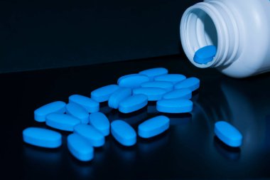 Siyah arka planda hap kutusu olan mavi haplar