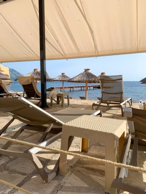 Kumsalın kumlu sahilinde şezlonglar