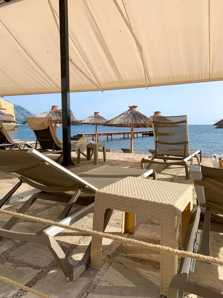 Kumsalın kumlu sahilinde şezlonglar