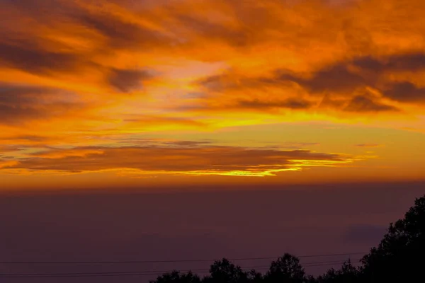 last light of sunset on sky and orange cloud ray around sun over Mountains of India