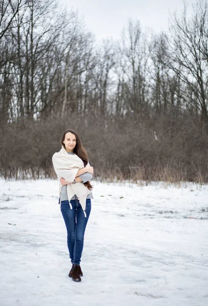 Sıcak bir eşarpla kış ormanında bir kız. Kız kış ormanlarında yürüyor.