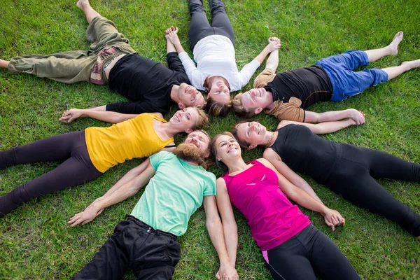 一群人躺在一圈绿草上 — 图库照片