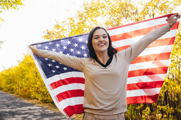 带着美国国旗的快乐微笑的年轻女人 — 图库照片