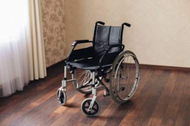 Pencere odasında boş tekerlekli sandalye.
