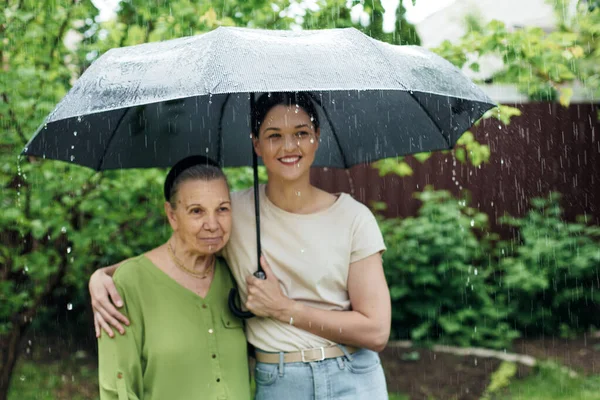 Old Woman Her Granddaughter Stand Rain Black Umbrella Stock Picture