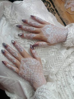 Duvağı olan beyaz elbiseli bir çift.