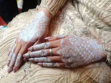 Duvağı olan beyaz elbiseli bir çift.