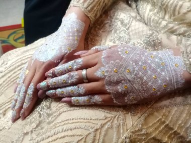 Beyaz bir bebek ayakkabısı tutan bir kadının ellerini kapat.