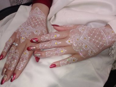 Beyaz elbiseli ve elinde alyansla güzel bir genç kadının yakın plan fotoğrafı..