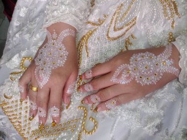 Gelin ve damadın beyaz gelinlik içinde, elleri sırtında görüntüsünü kapatın.