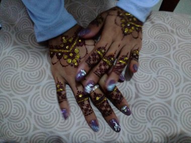 Siyah bir arka planda dövmesi olan bir kadının ellerini kapat.